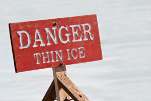 danger thin ice - warning sign by a lake