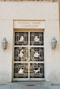 Washington, DC - October 11, 2009: An entrance to the Federal Trade Commission office building in downtown Washington, DC. The doorway features an ornate bronze grillwork depicting various commercial trade conveyances. This is one of the smaller side entrances. The FTC is a government agency that regulates consumer protection laws, antitrust laws, trademark registration, antitrust laws, and other trade and commerce issues.
